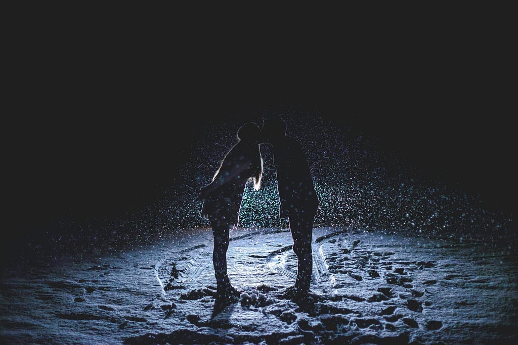 Couple kissing in the snowy dark