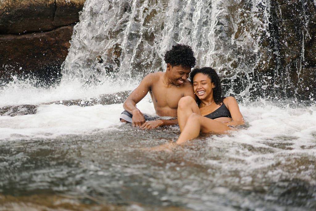Couple relaxing together in a waterfall.