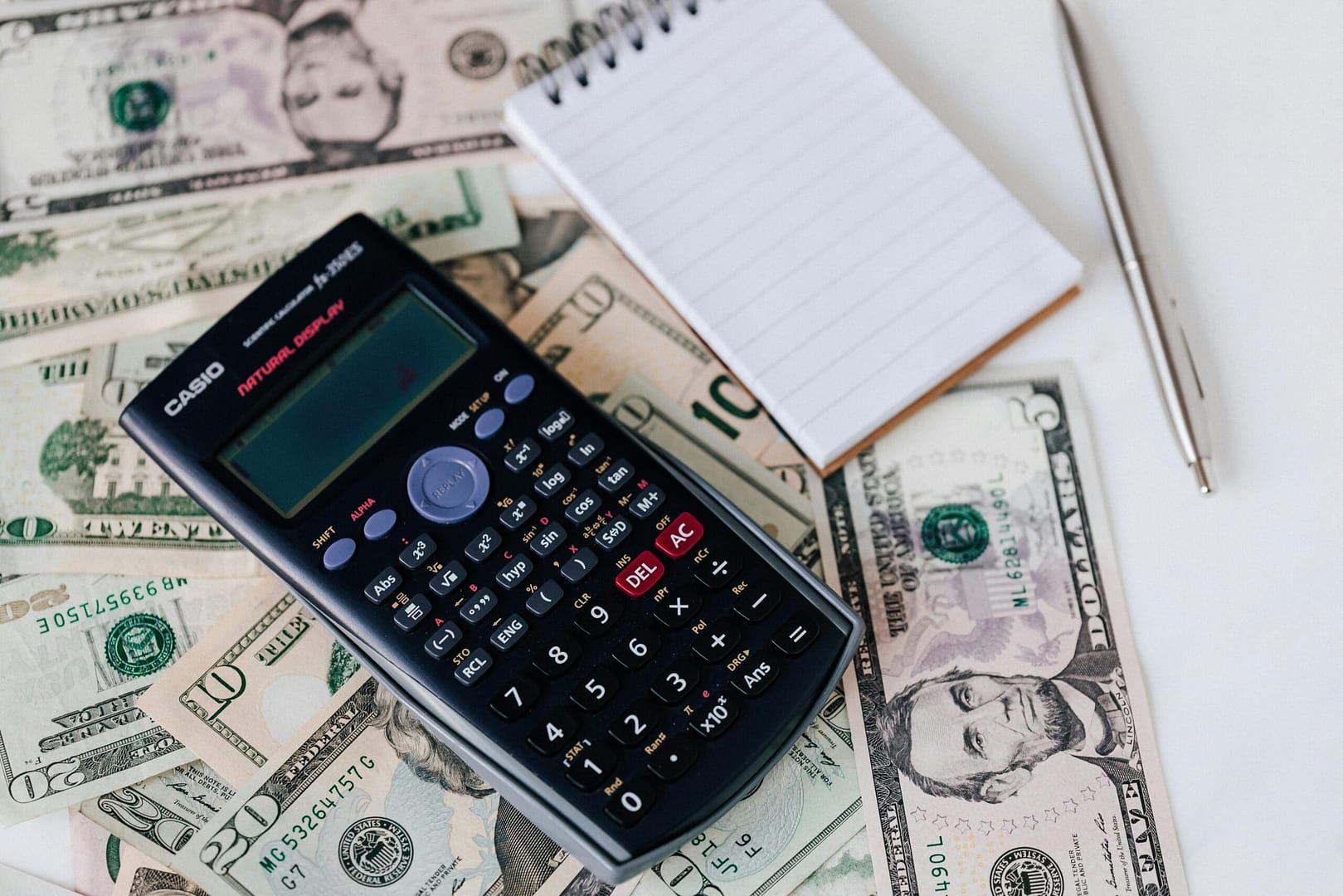 budget Calculator with a pad of paper and pen to make a budget