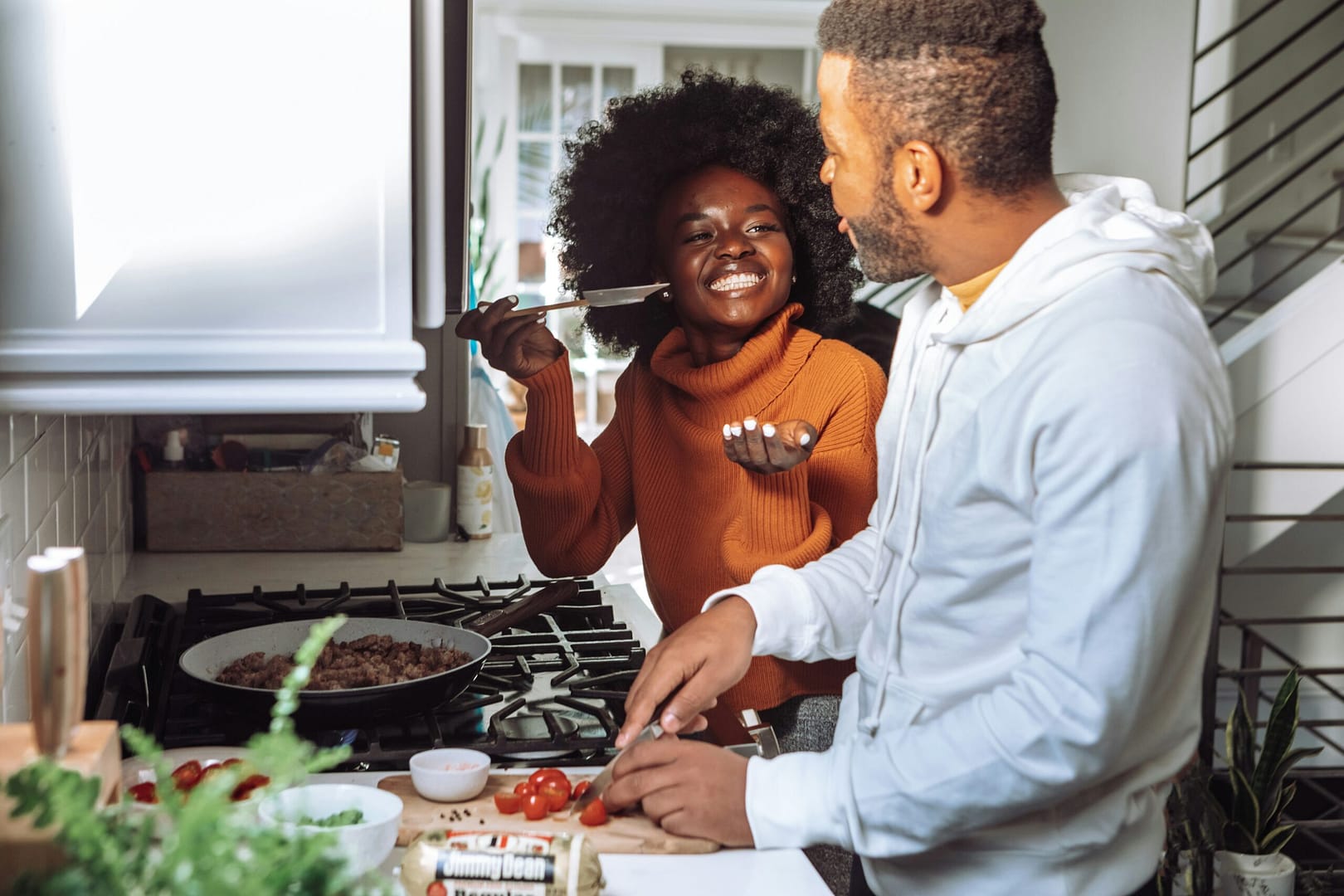 Couple Cooking Couple happily cooking with each other and trying the food.