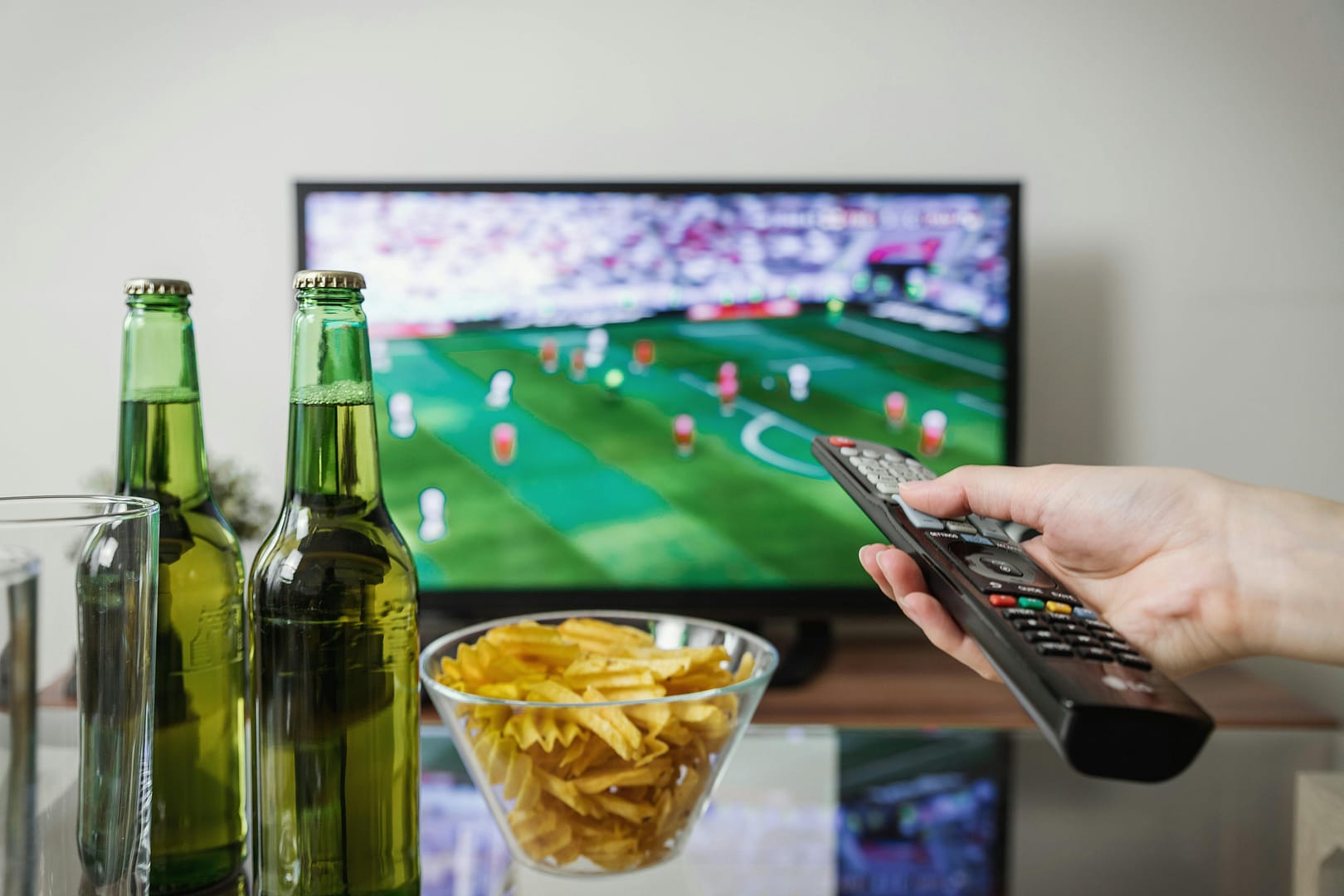Watching the Game Sports on TV with snacks and drinks on table