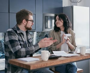 pexels-mikhail-nilov-6963034 Couple having discussion at the kitchen table,