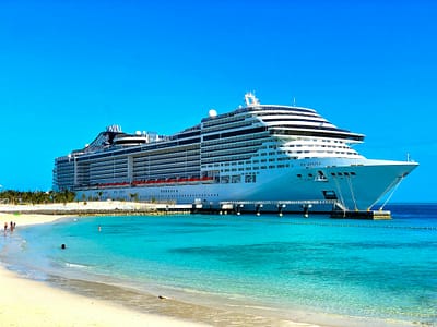 Cruise ship in port with sandy beach and turquoise water