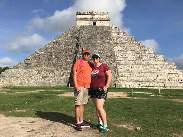 Ben and Erica travel agents and advisors standing in front of the Aztec ruins of Chichen Itza in Mexico.