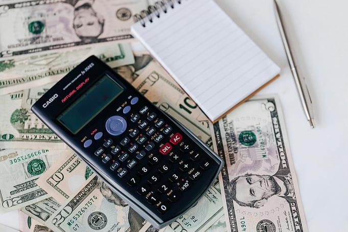 budget Calculator with a pad of paper and pen to make a budget