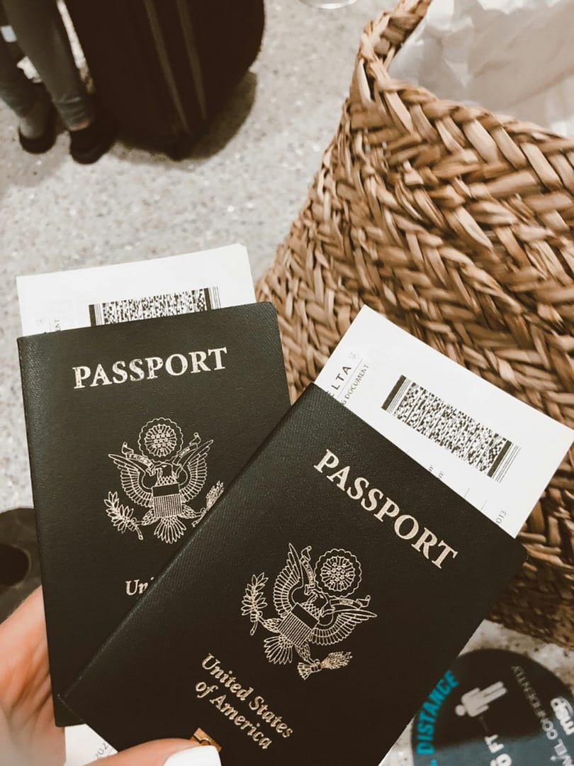 two-passports two passports being held in someone's hand at the airport